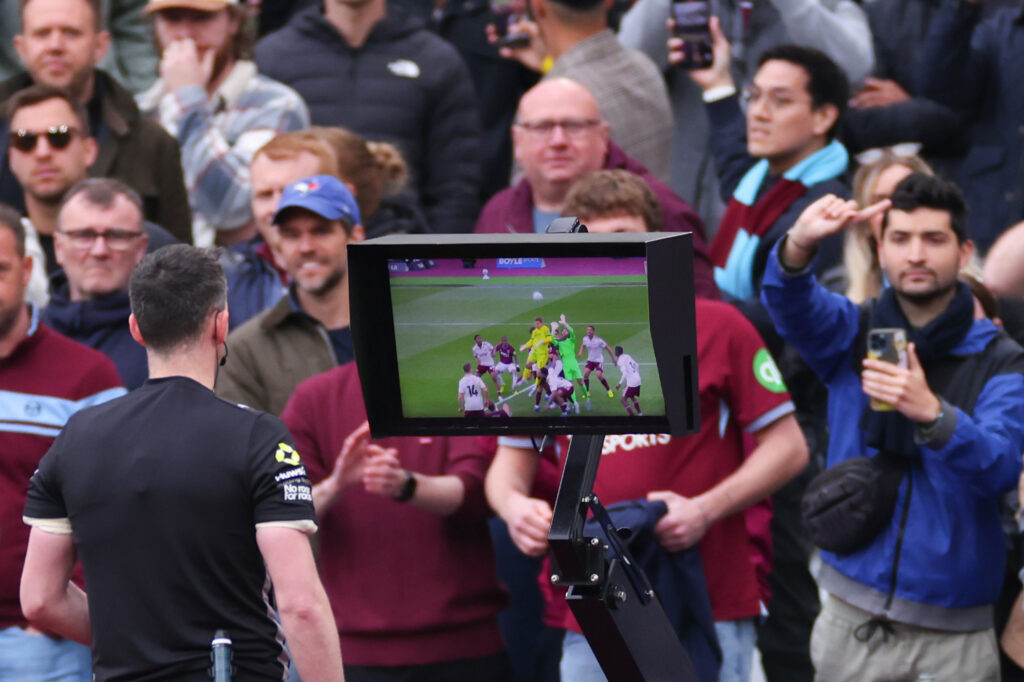Chris Kavanagh checks the pitch-side monitor